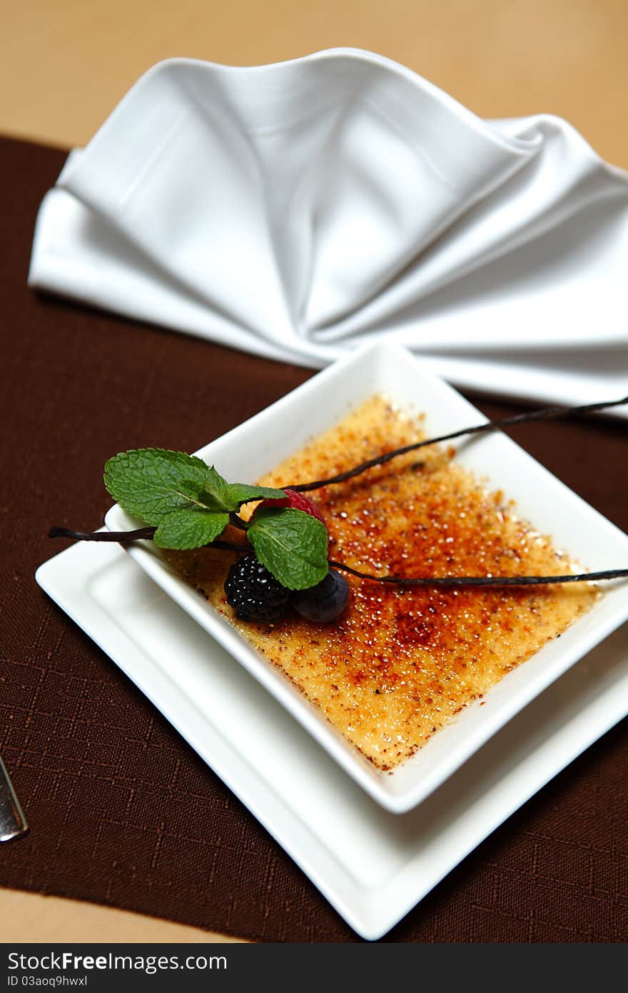 Dessert creme brulee with fresh mint and berries