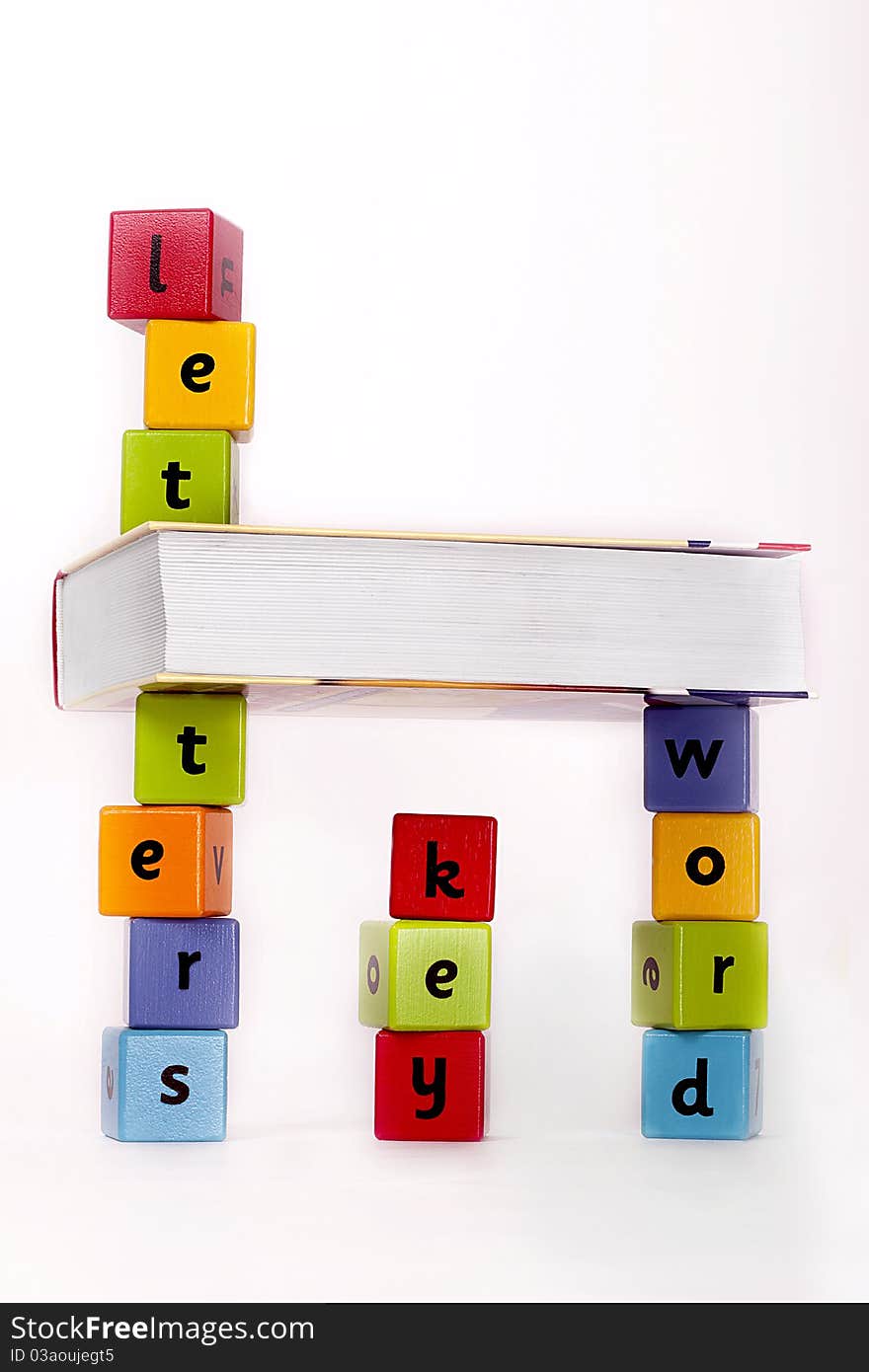 Book and wooden blocks with letters stacket up. Book and wooden blocks with letters stacket up