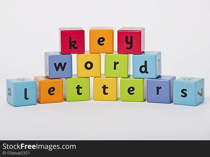 Wooden blocks with letters stacked up on white background. Wooden blocks with letters stacked up on white background