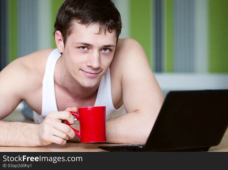 A young man in a white robe with laptop