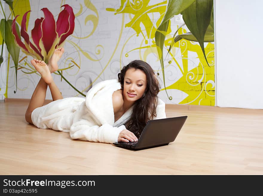 A young woman in a white robe with laptop