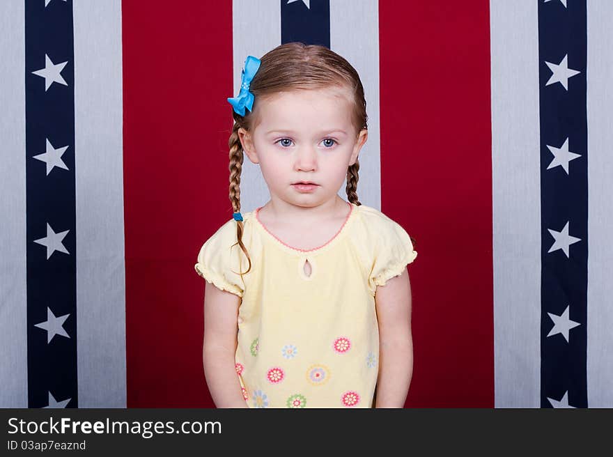 A confused child standing in front of an American Flag style background. A confused child standing in front of an American Flag style background.