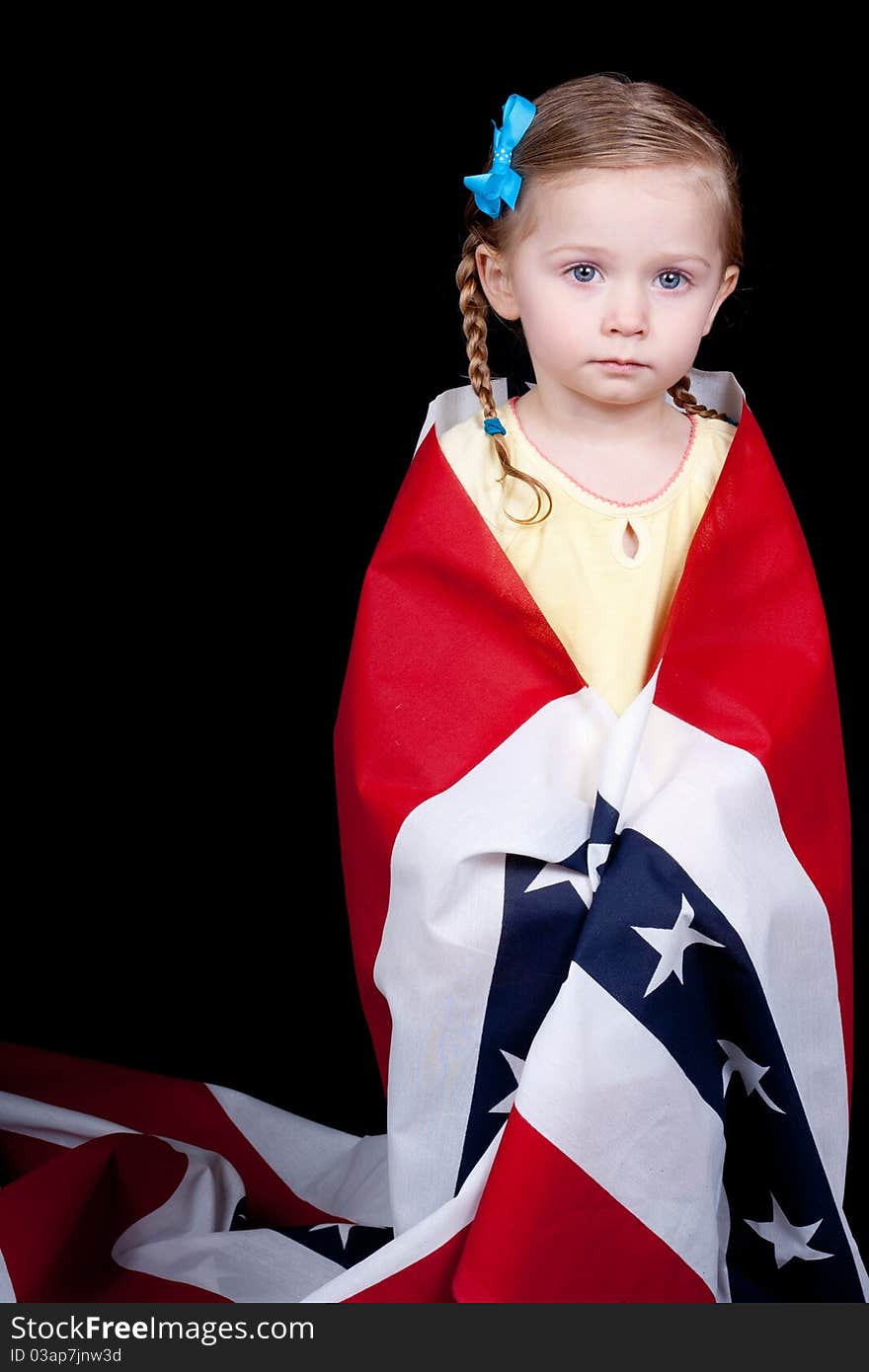 An innocent American girl with a patriotic fabric wrapped around her.