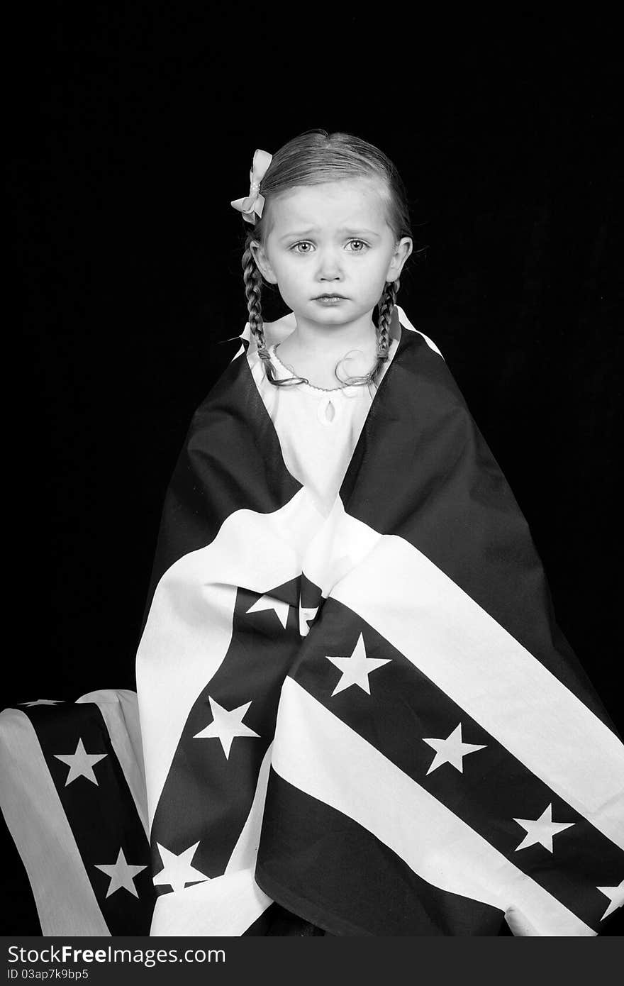 A girl clothed in an American flag design. The photograph is in black and white. A girl clothed in an American flag design. The photograph is in black and white.