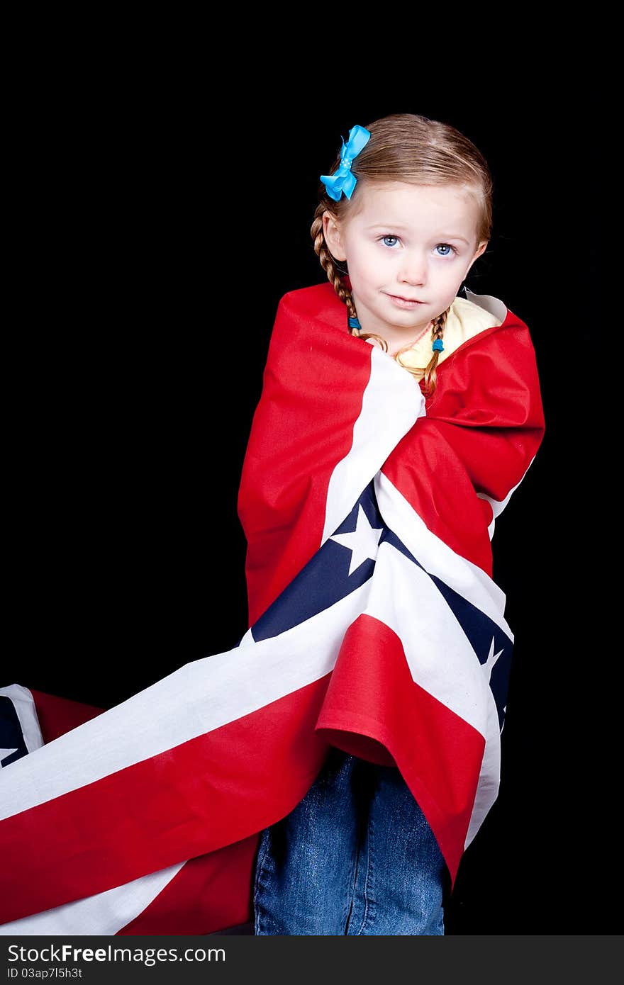 Girl with a confused look on her face. She is drapped in a patriotic design. There is a black background. Girl with a confused look on her face. She is drapped in a patriotic design. There is a black background.