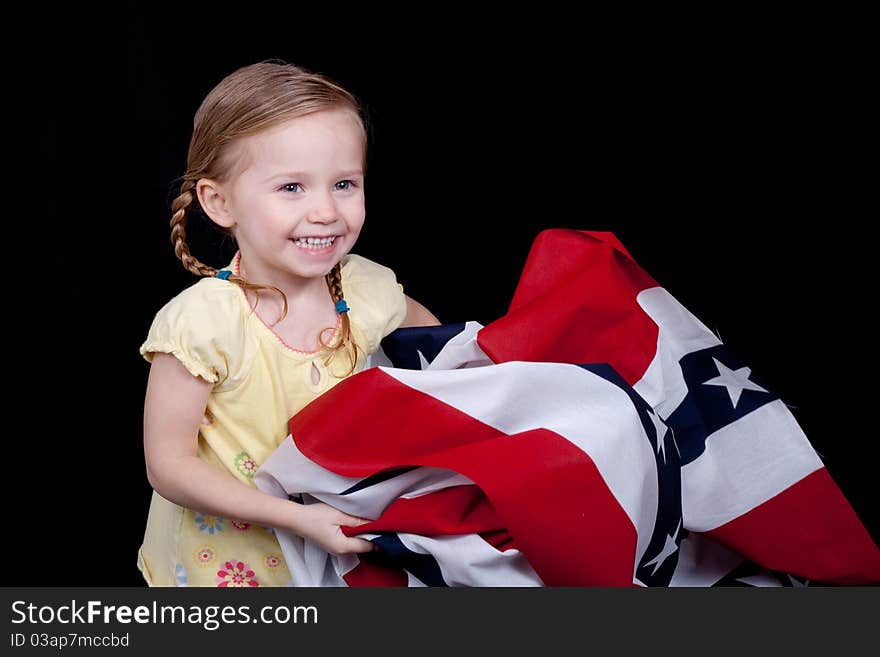 A cute girl folding/holding the American Flag. A cute girl folding/holding the American Flag