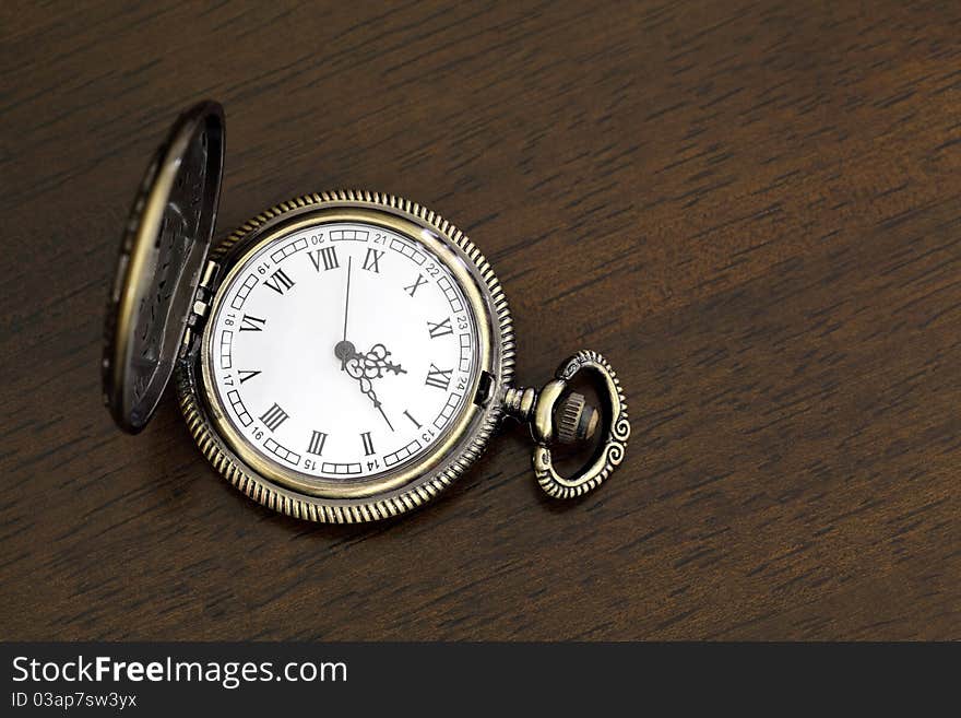 Antique pocket watch on a wood board