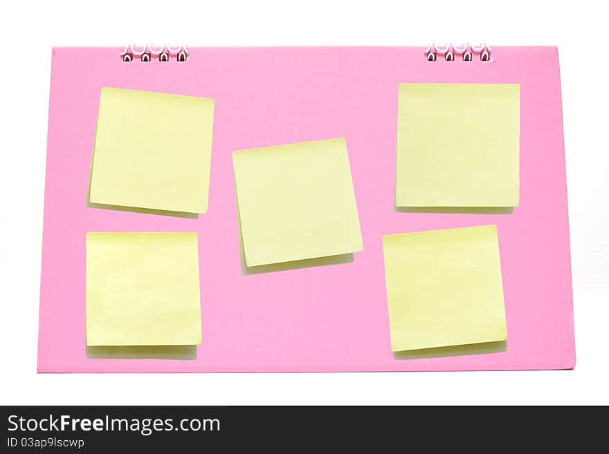 Yellow memo stick on Pink calendar isolated