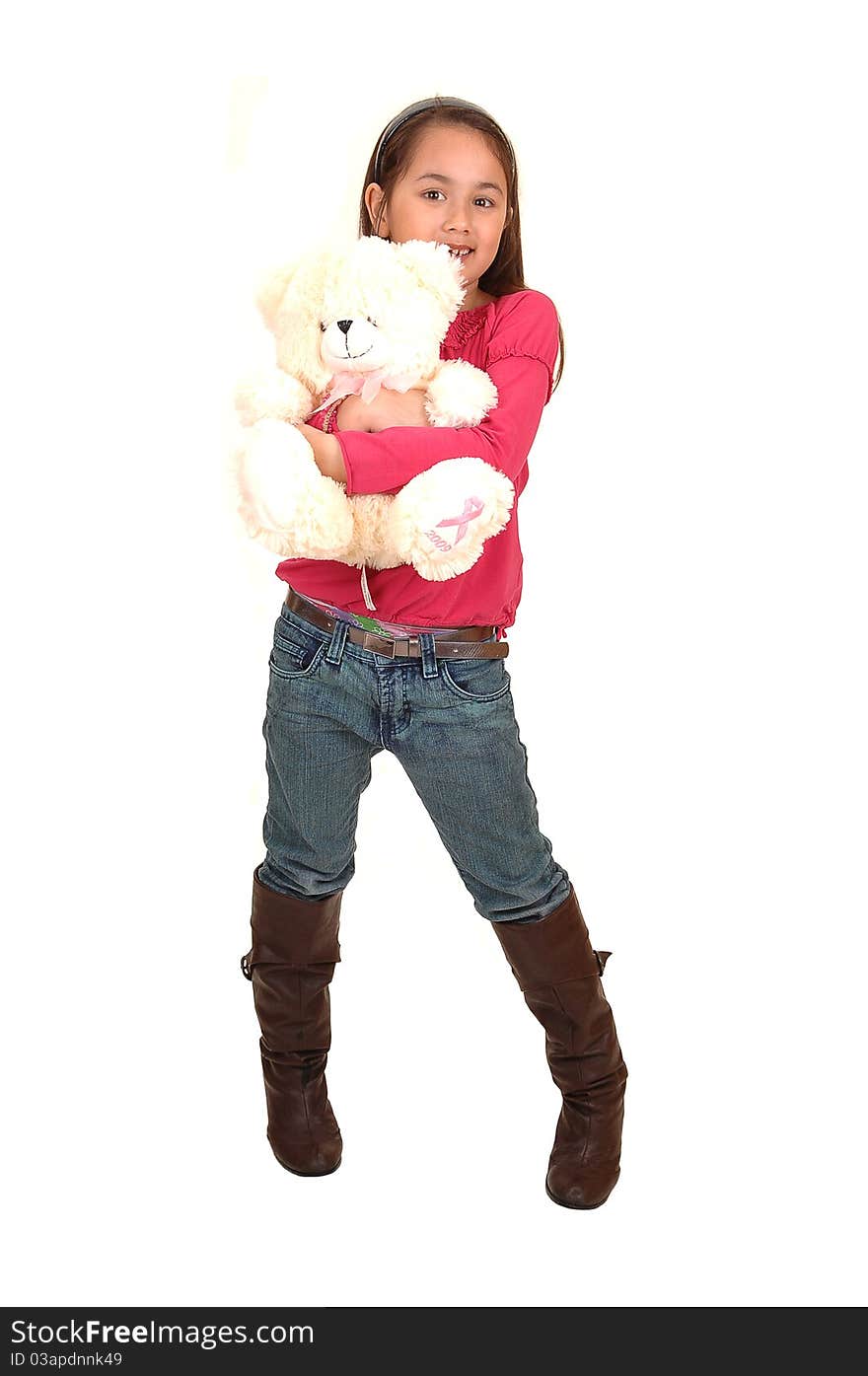 A young pretty girl standing in the studio with her white teddy bear in her arms, in jeans and boots for white background. A young pretty girl standing in the studio with her white teddy bear in her arms, in jeans and boots for white background.