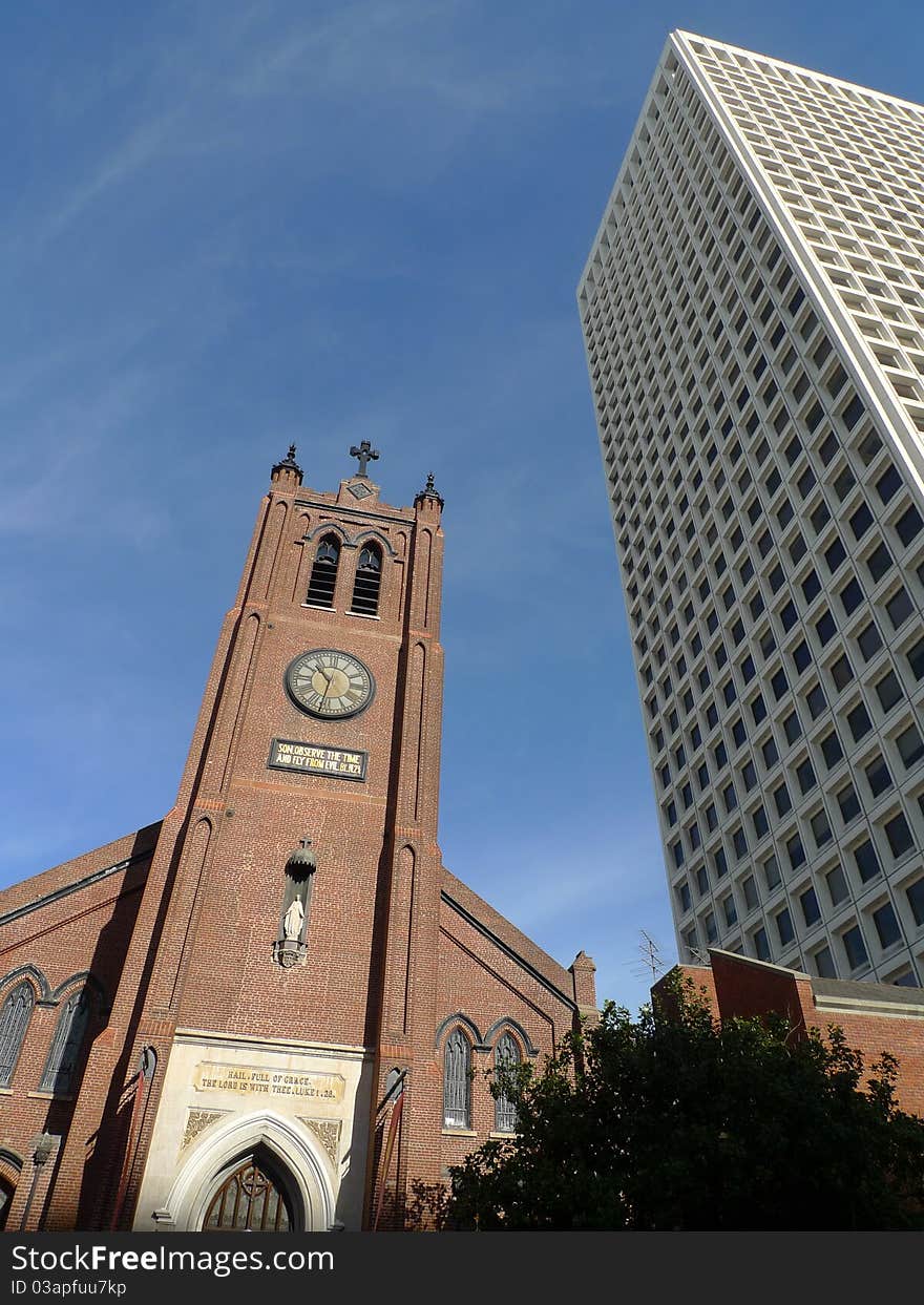 Red church in the downtown beside a skyscrape