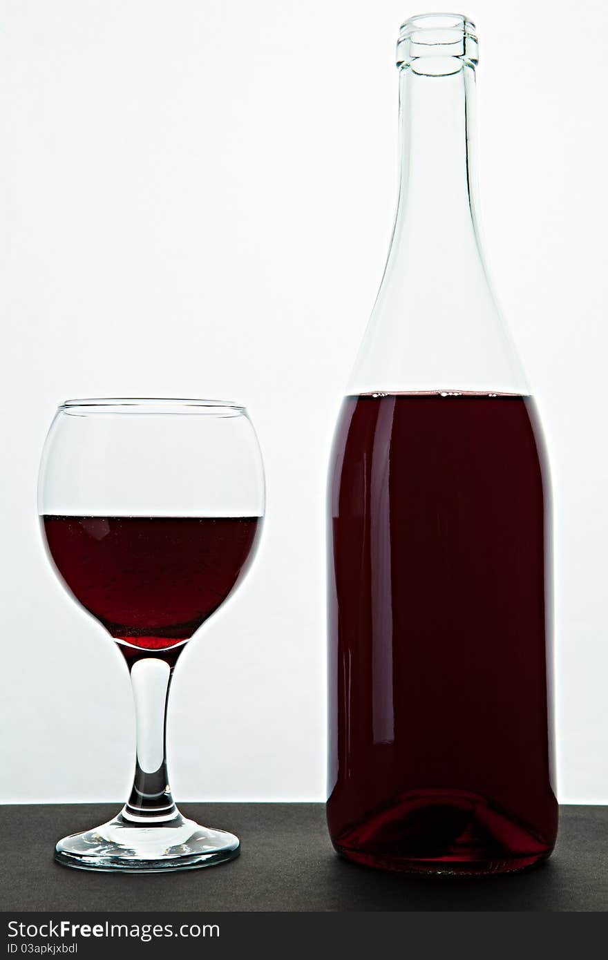 Open bottle and glass with red wine on a table