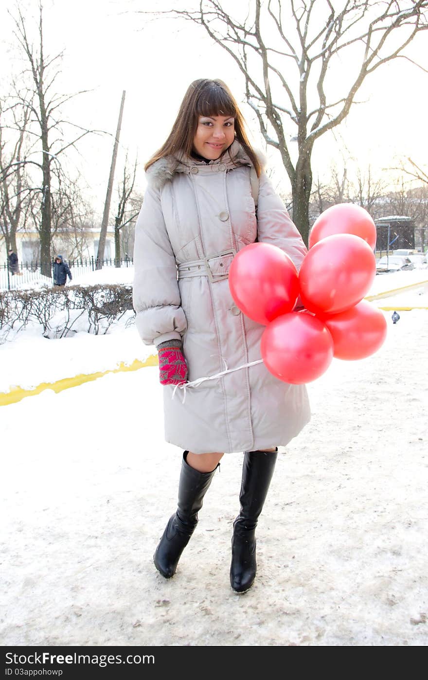 Portrai of beautiful smiling young girl with pink and red balloon in winter park. Portrai of beautiful smiling young girl with pink and red balloon in winter park