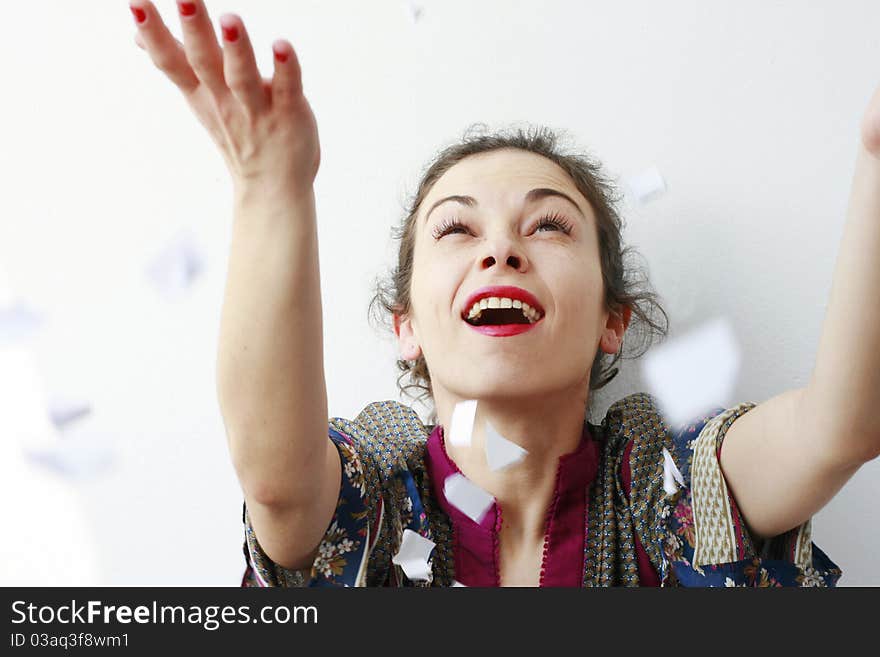 Happy woman throwing pieces of paper in the air