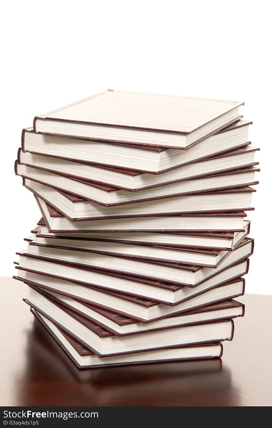 Stack of real books in wound formation, leather binder side view, isolated on white background