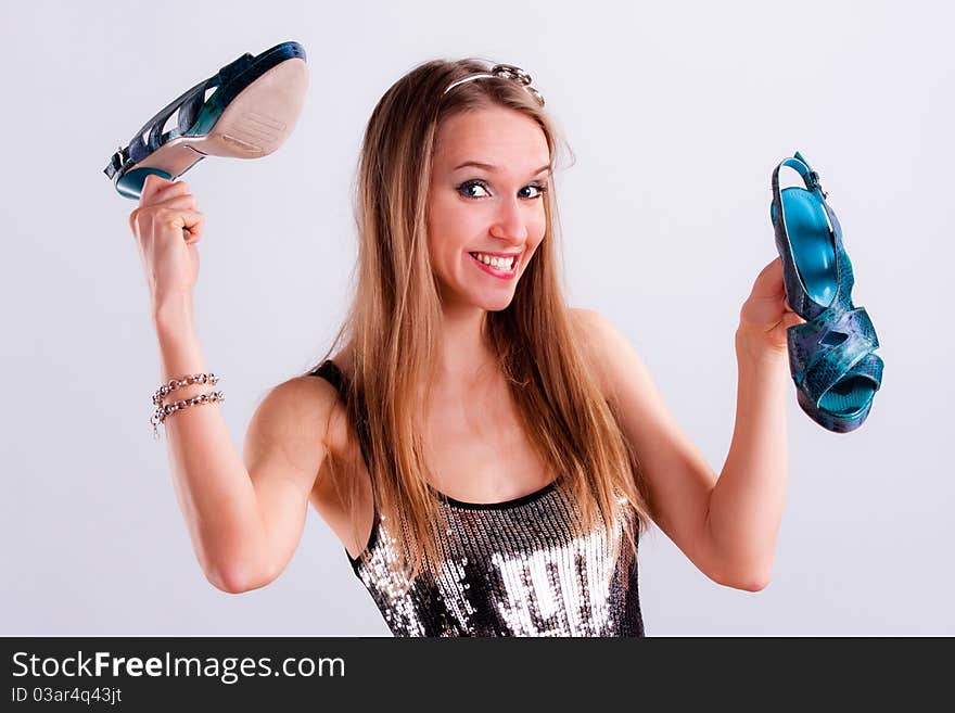 Pretty girl with a pair of shoes in hands