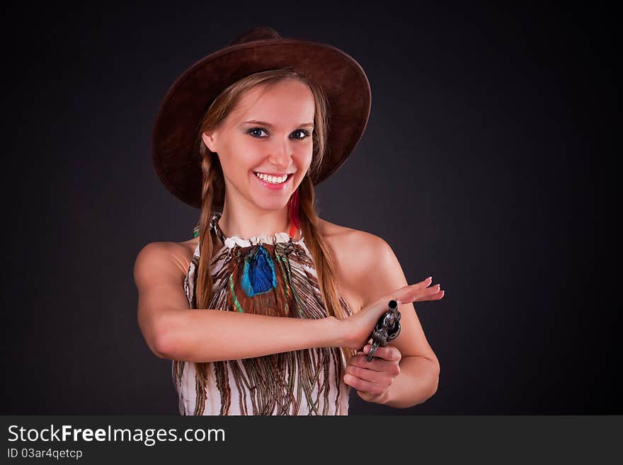 The American Indian girl in a cowboy's hat holds a pistol