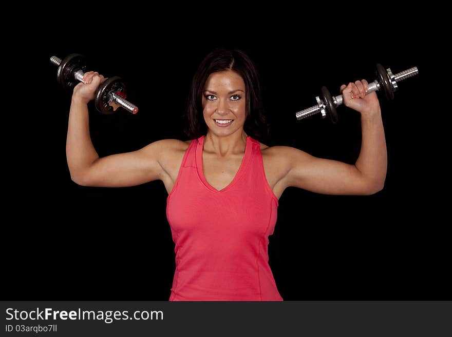 A woman is holding some weights with her muscles showing. A woman is holding some weights with her muscles showing