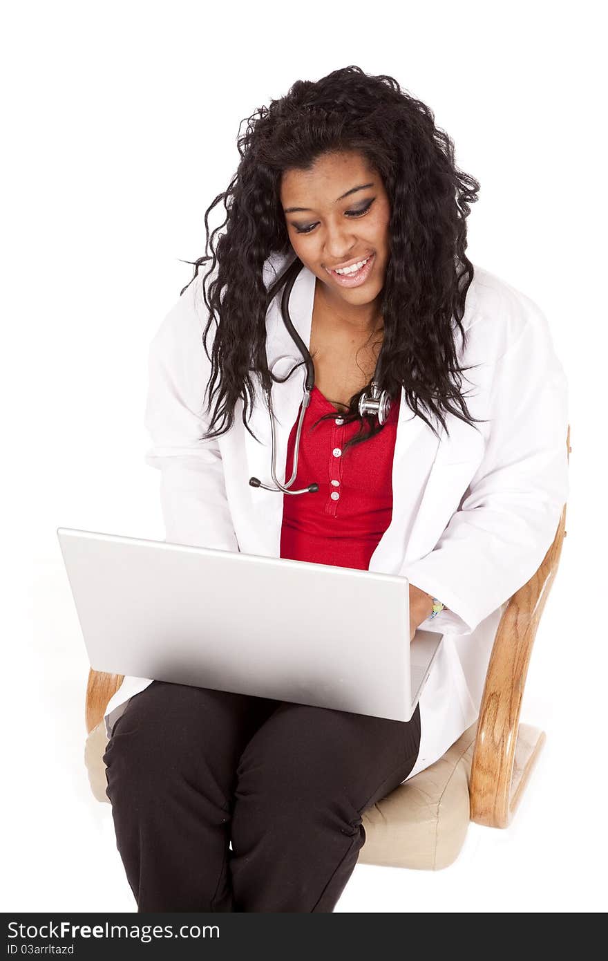 A woman doctor is smiling at her laptop. A woman doctor is smiling at her laptop.