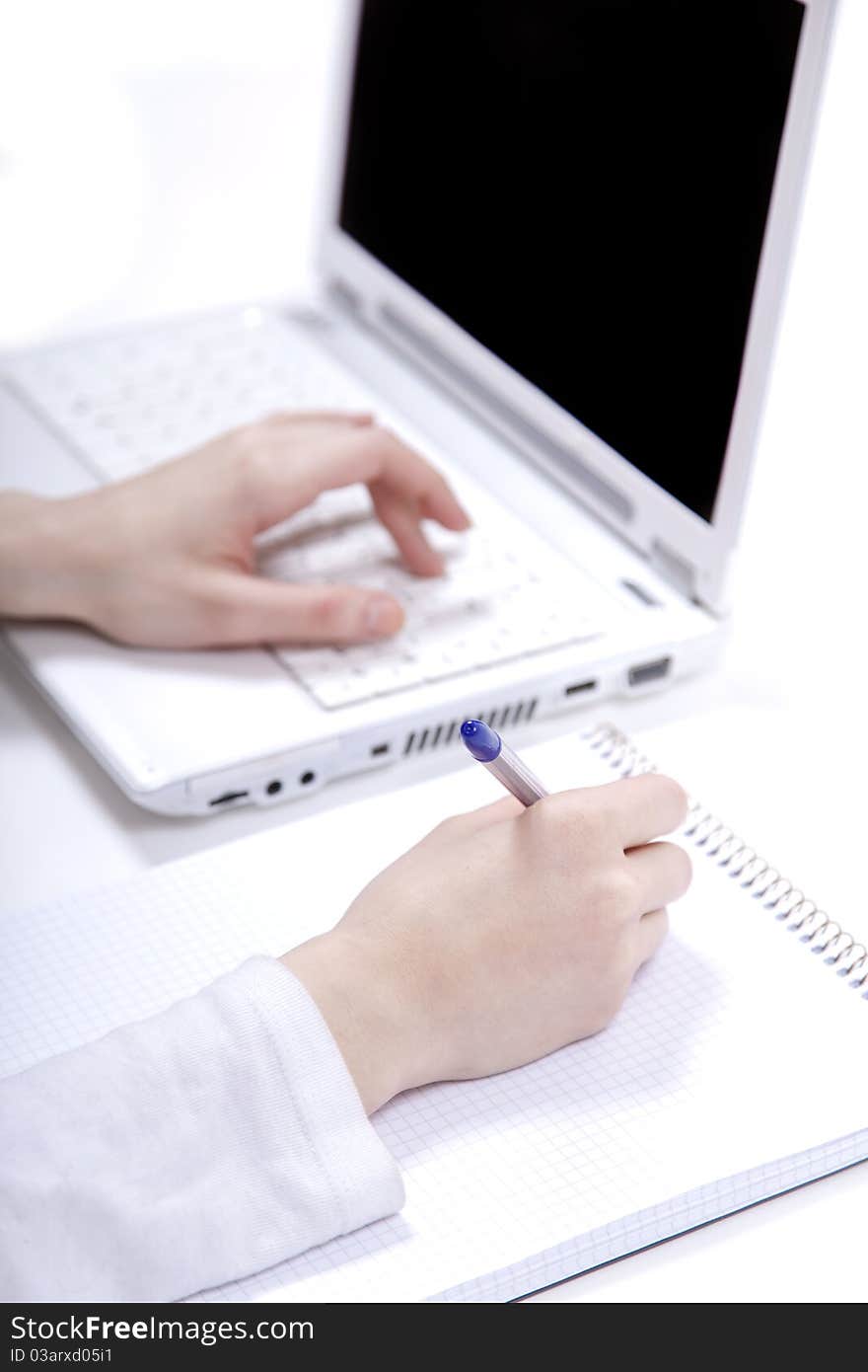 Business notebook with laptop and pen in hand.