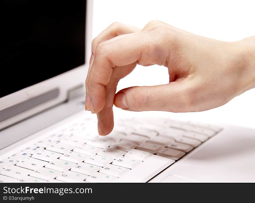 Human hand over laptop keypad during typing. Studio shot.