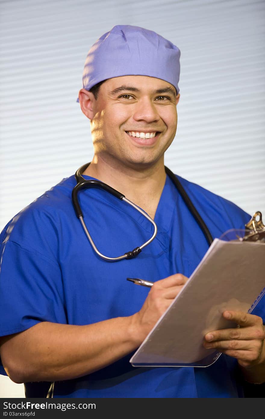 Close-up of young man wearing blue scrubs and surgical cap. Close-up of young man wearing blue scrubs and surgical cap.