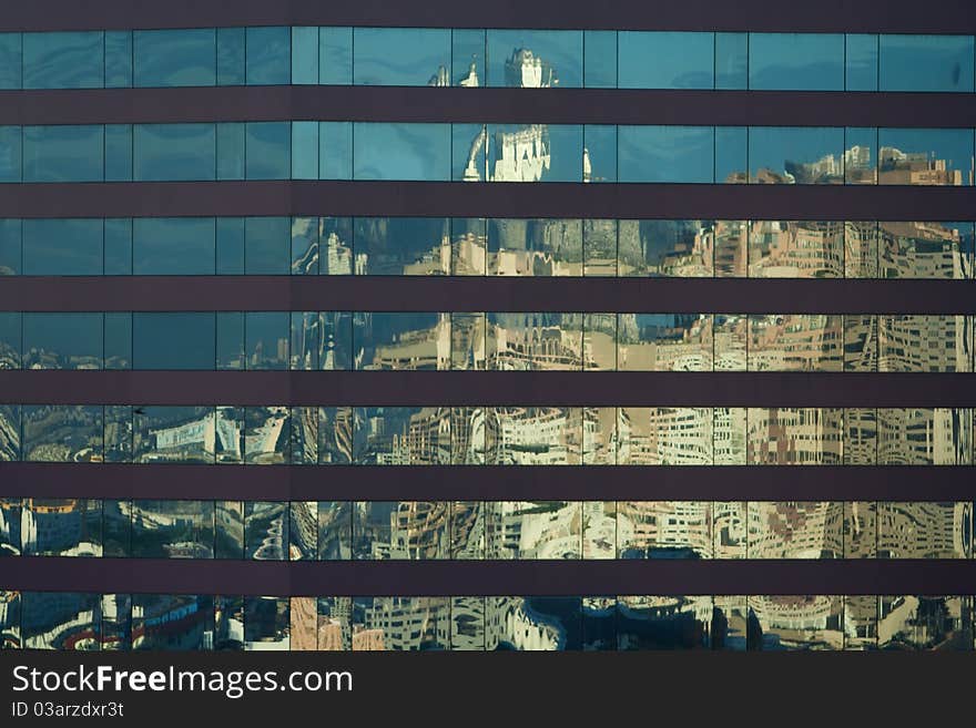 Angled shot of an office building with shiny blue glass facade on a sunny day.