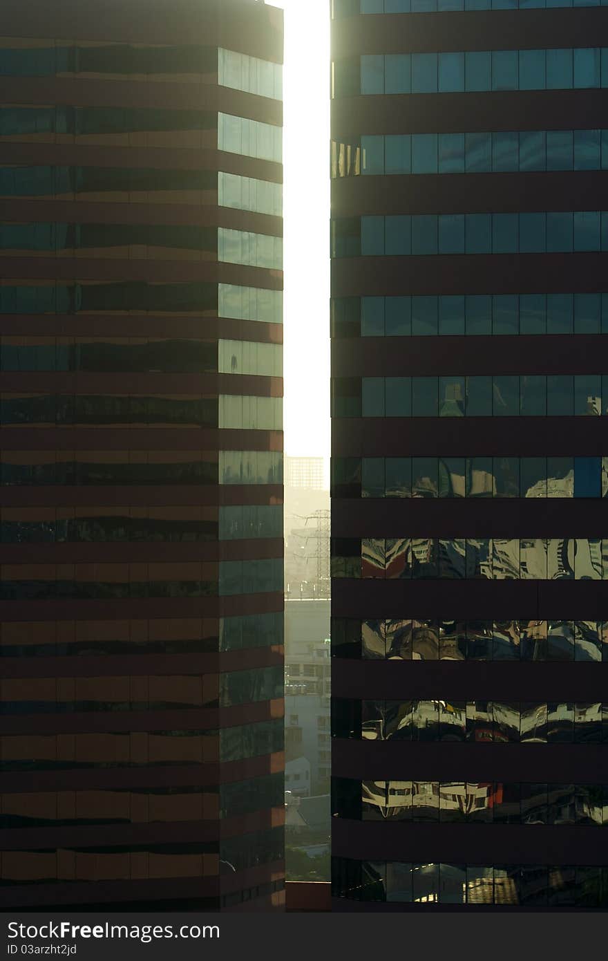 Angled shot of an office building with shiny blue glass facade on a sunny day.