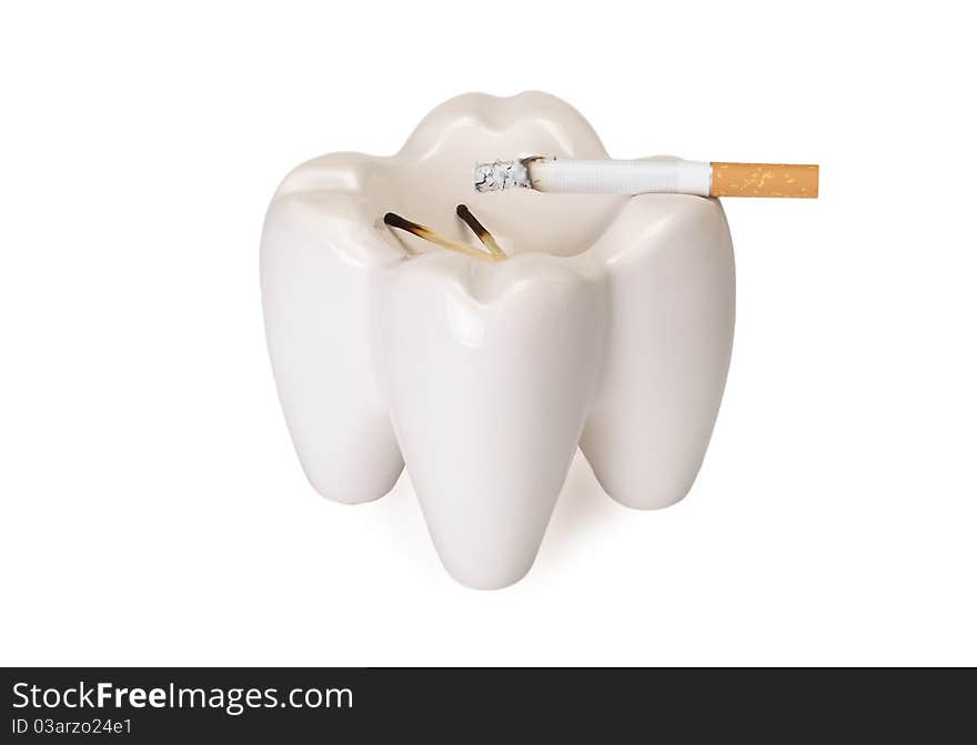 Ashtray in the form of a tooth with a stub on a white background