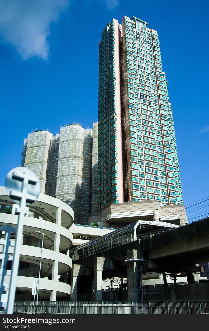 Angled shot of an office building with shiny blue glass facade on a sunny day.