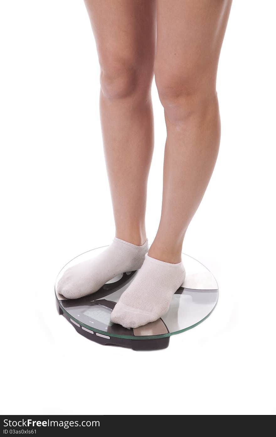 A woman with her legs on the bathroom scales, wearing socks. A woman with her legs on the bathroom scales, wearing socks.