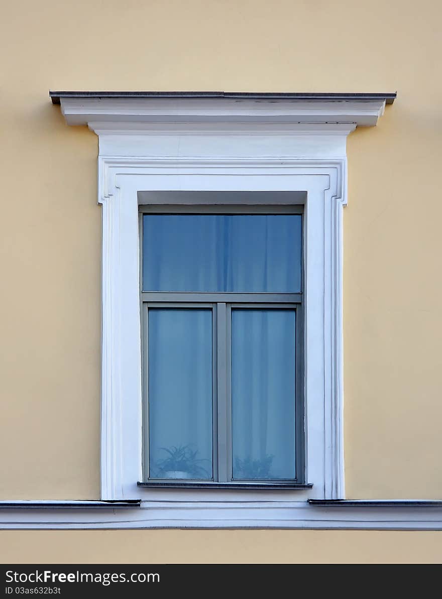 Old window on the yellow wall in the Classical style. Old window on the yellow wall in the Classical style