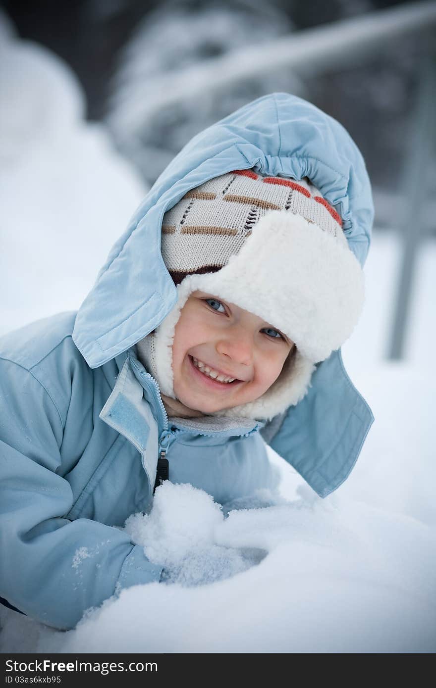 Little boy outdoors in winter, smiling. Little boy outdoors in winter, smiling.