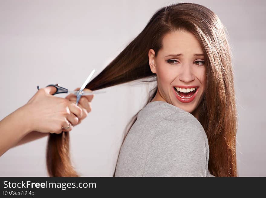 Pretty girl gets hair cut with sissors. Pretty girl gets hair cut with sissors