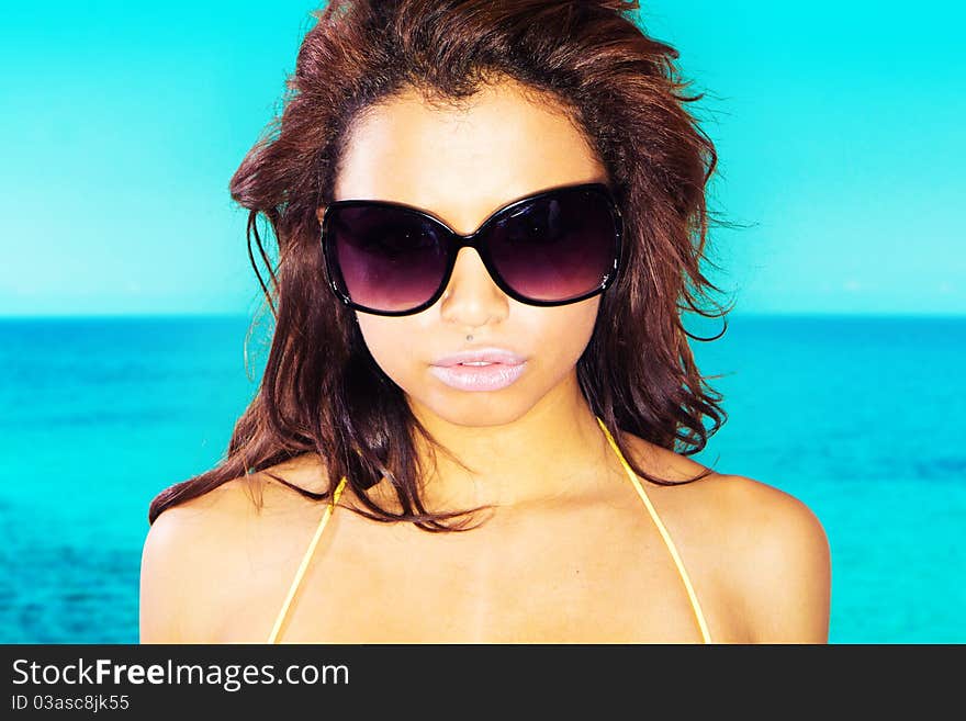 Stunning young lady posing in yellow bikini over aqua blue background. Stunning young lady posing in yellow bikini over aqua blue background