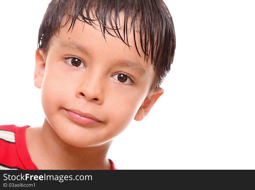 Child with a small smile on his face over white background