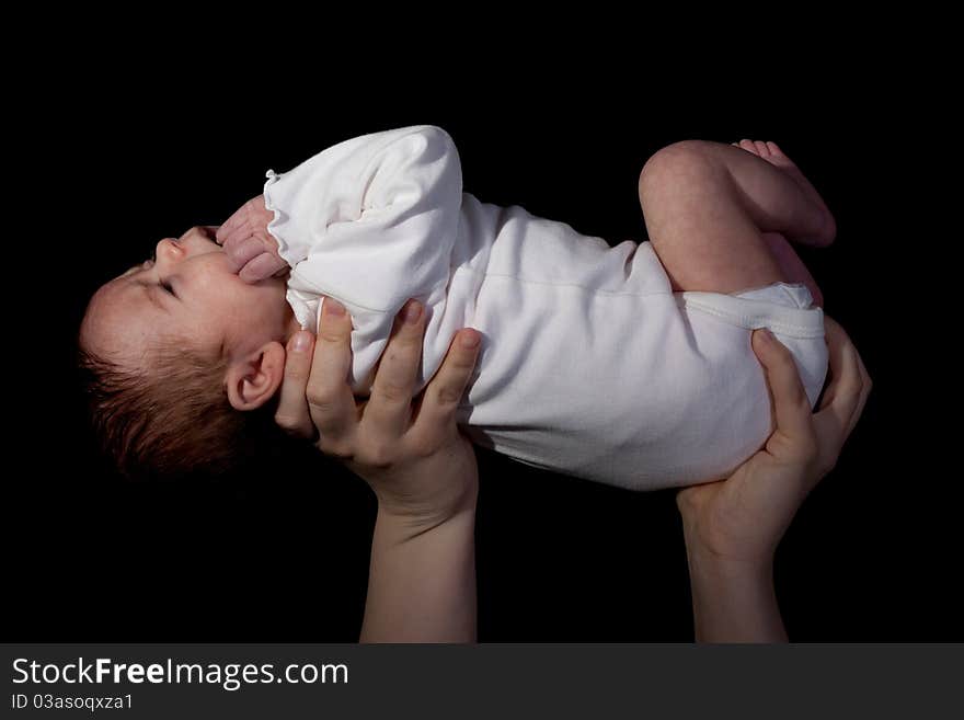 A mother raising her baby up to the light.  The photograph is side lit to add emotion to it. A mother raising her baby up to the light.  The photograph is side lit to add emotion to it.