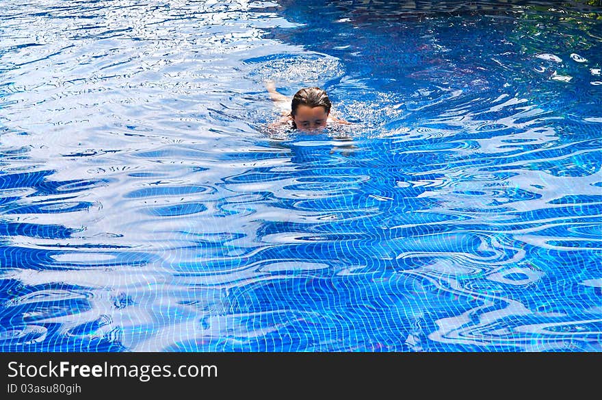 Tween white girl swimming in a pool.