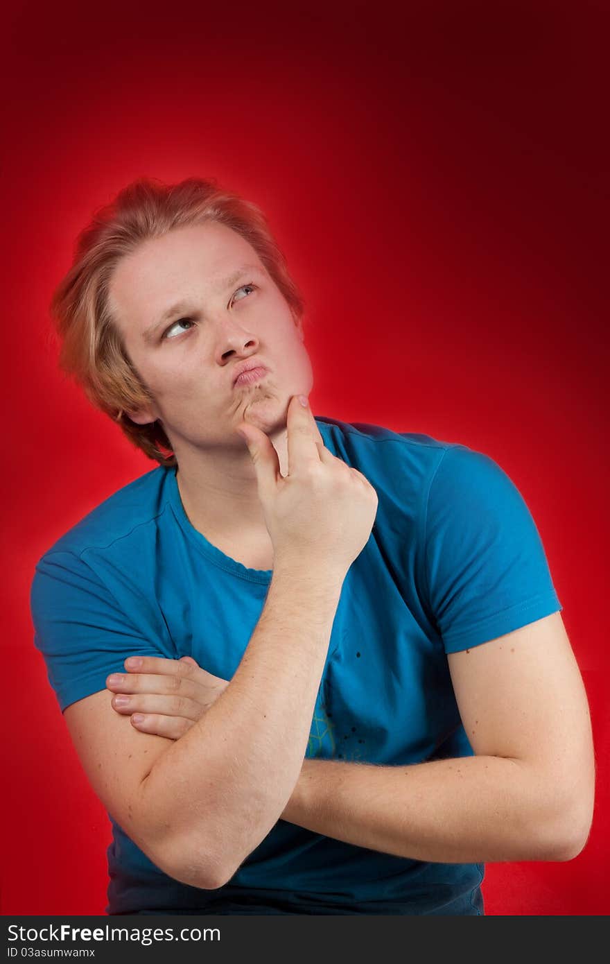 Young man with thoughtful pose on red background. Young man with thoughtful pose on red background