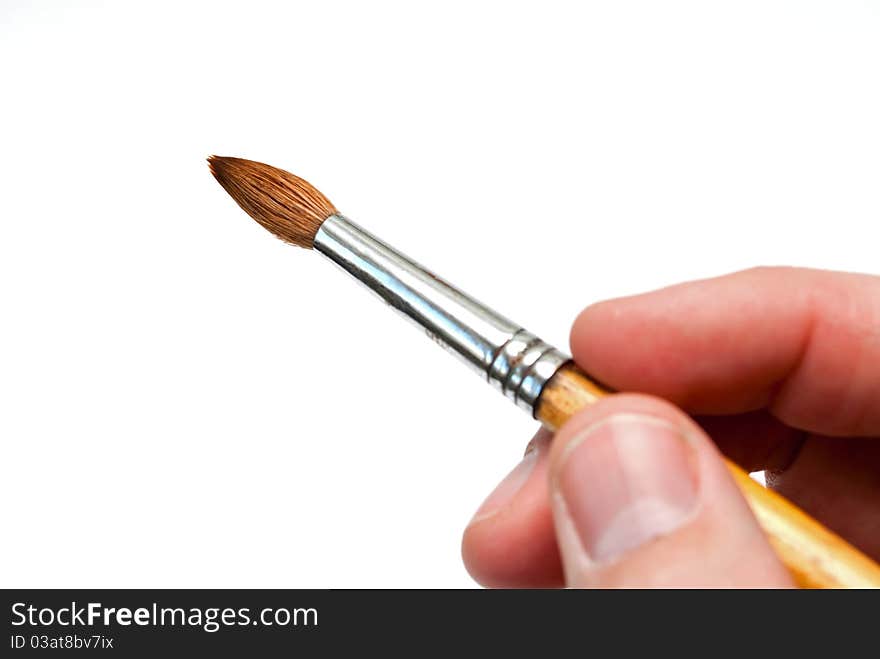 Brush to paint in his hand on a white background. Brush to paint in his hand on a white background