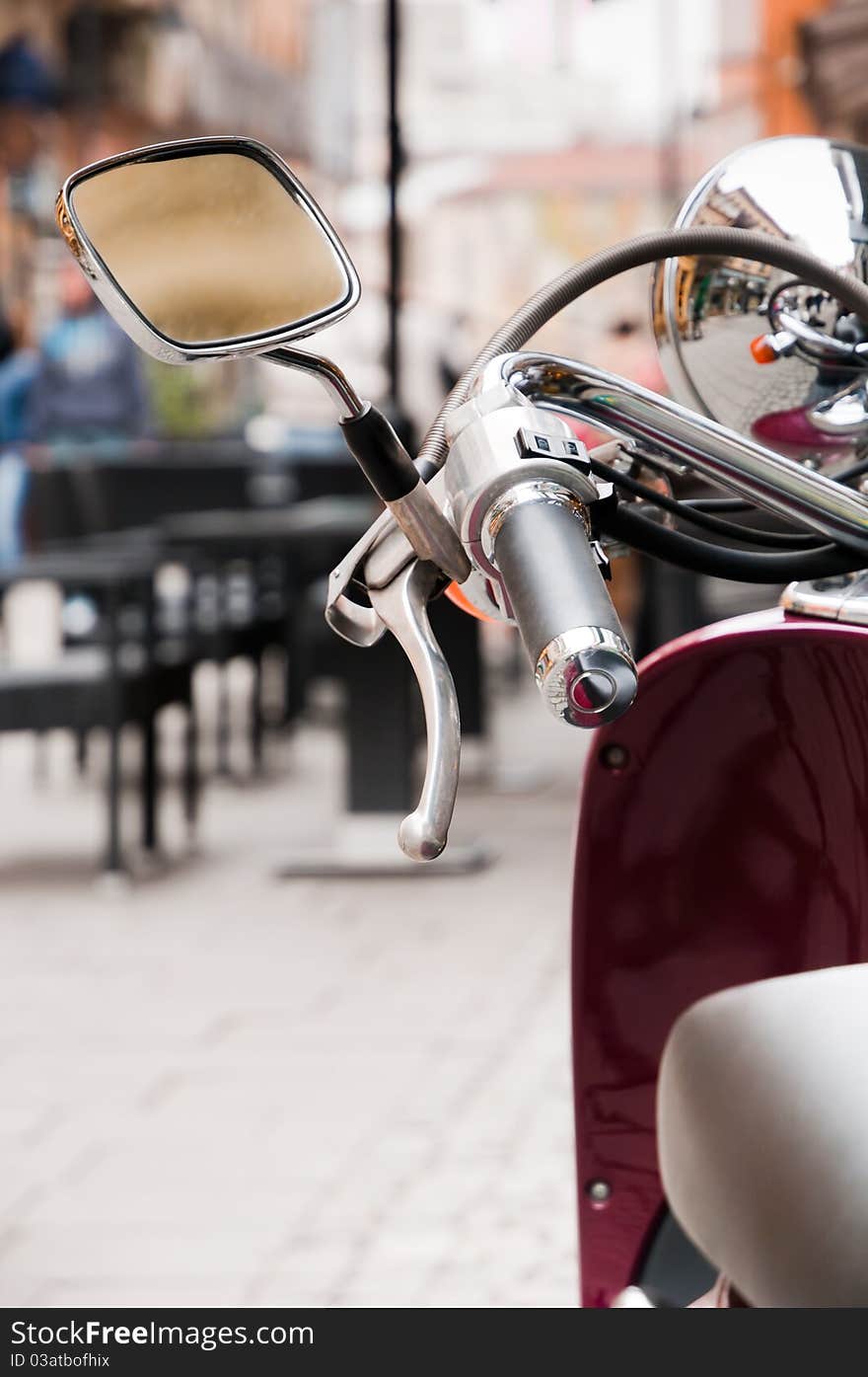 Motor scooter left mirror and handlebar on a small street in the historical center of Bucharest. Motor scooter left mirror and handlebar on a small street in the historical center of Bucharest.