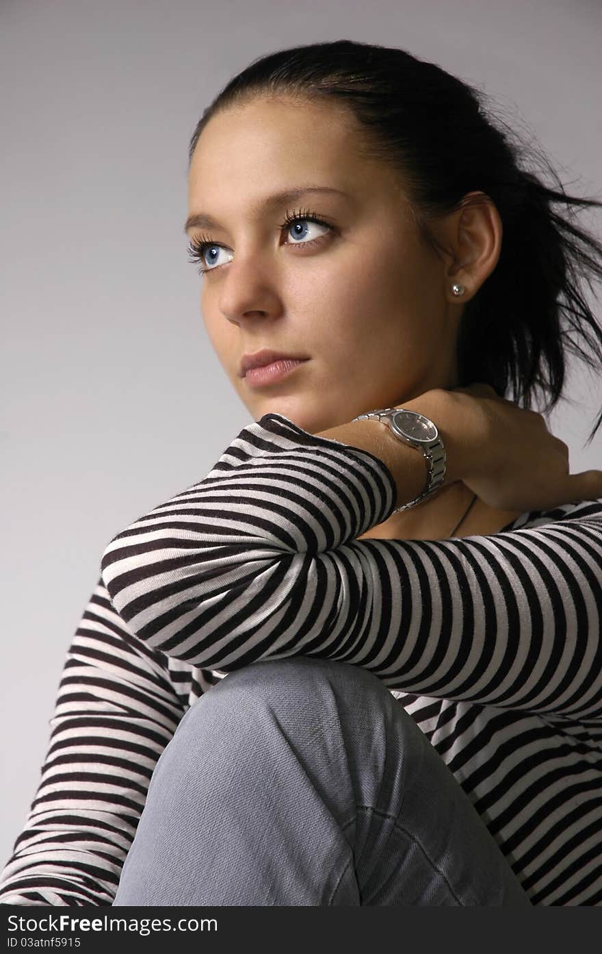 The beautiful brunette on a grey background