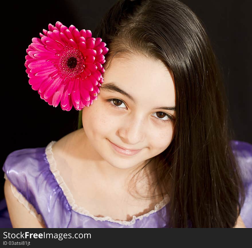 Cute girl with pink flower. Shoot in studio