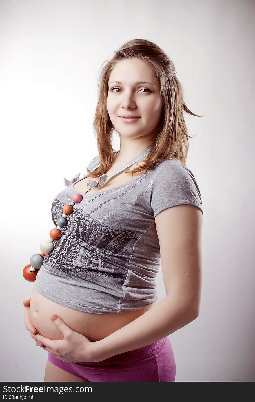 Funny pregnant woman in bright clothing and beads