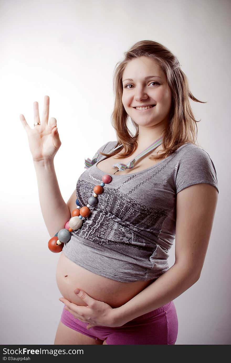 Funny pregnant woman in bright clothing and beads