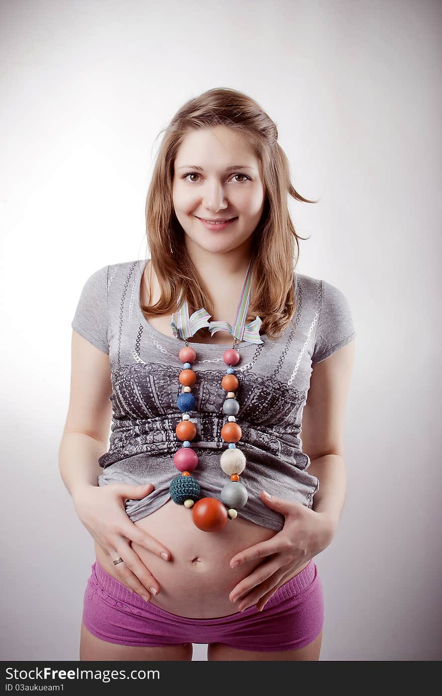 Funny pregnant woman in bright clothing and beads