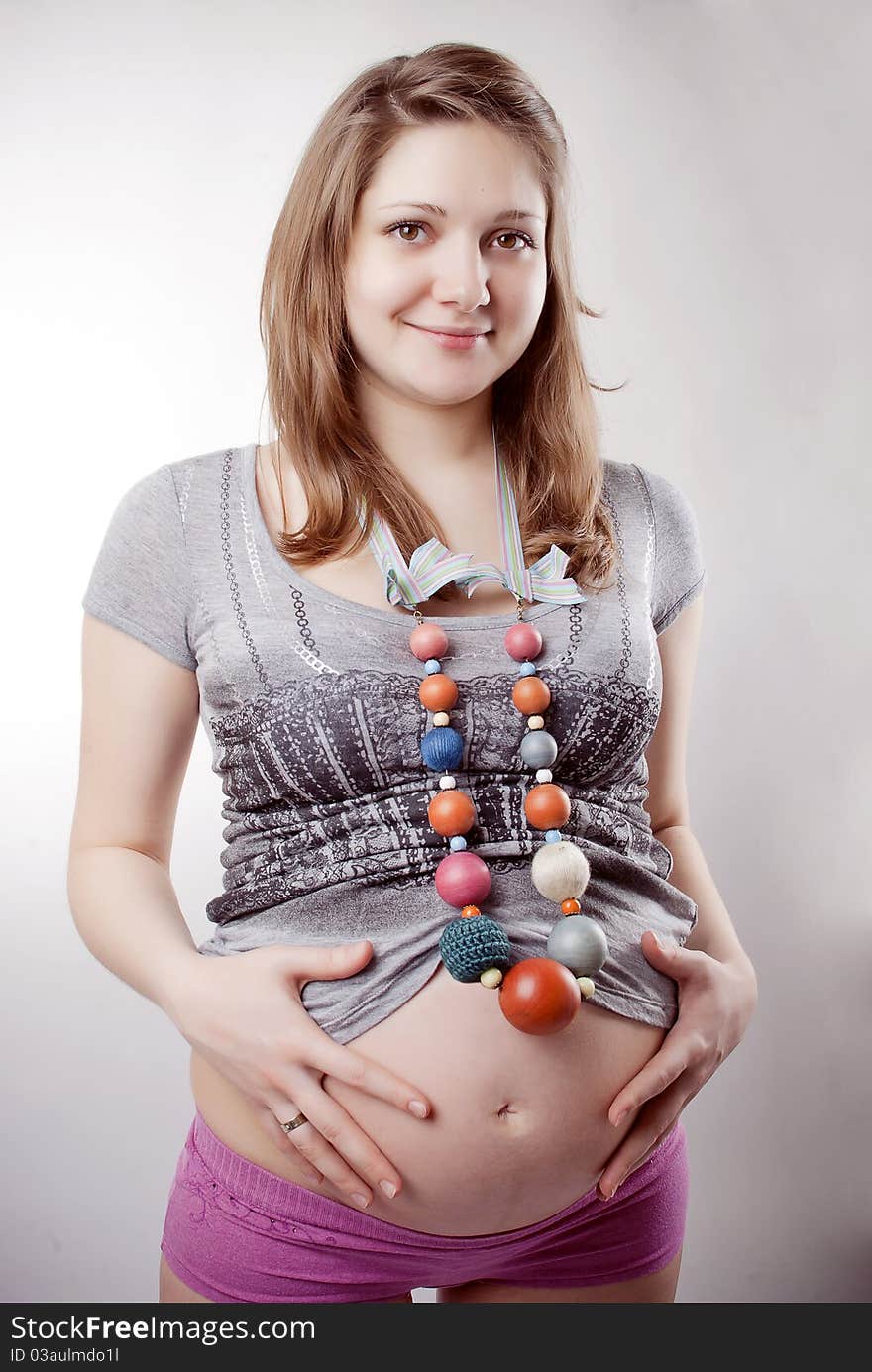 Funny pregnant woman in bright clothing and beads