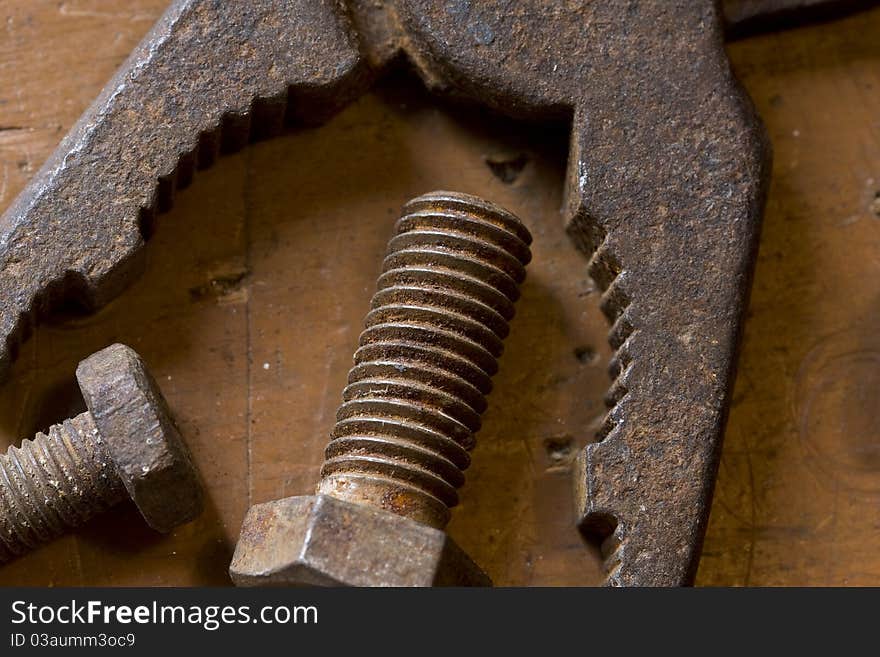 Old rusted pliers and screwbolts on workbench