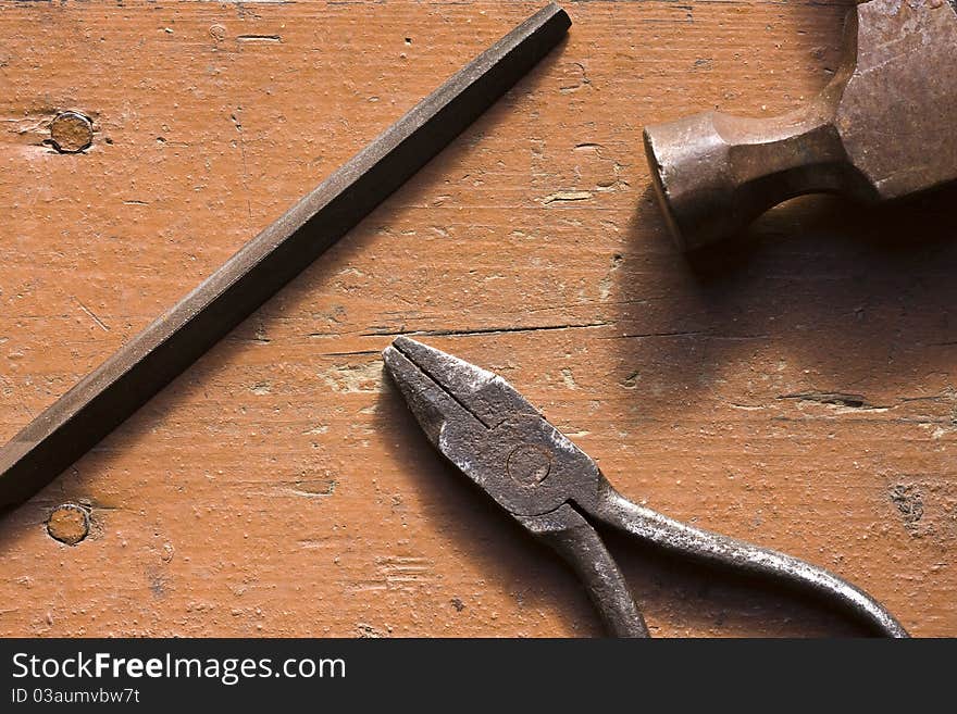 Old rusted pliers and screwbolts on workbench