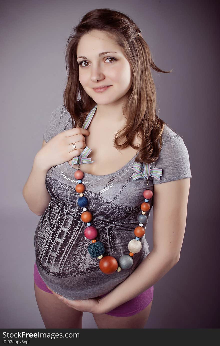 Funny pregnant woman in bright clothing and beads