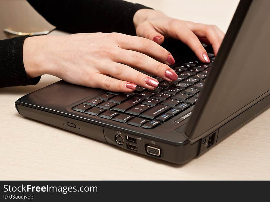 Female hands typing on laptop keyboard